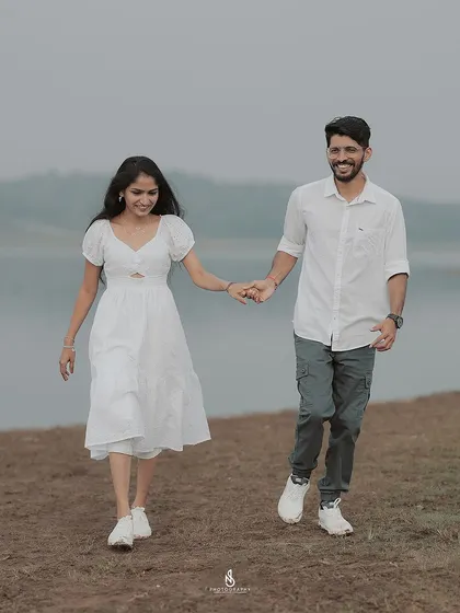 A simple and sweet walking shot along the water's edge. The clean, coordinated white outfits work beautifully with the muted landscape.
