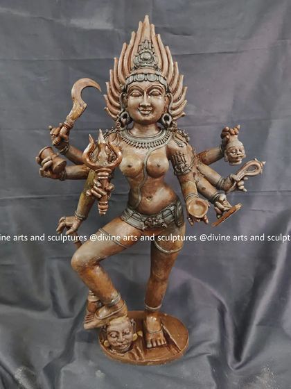 A wax model of the goddess Kalika in a powerful standing pose. Her multiple arms holding various weapons are sculpted with precision, defining her fierce character.
