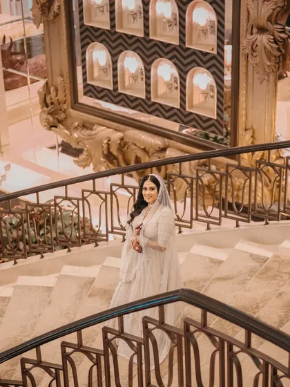 A high-angle shot capturing the bride's elegance and the grandeur of the venue's architecture.