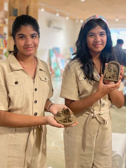 These twin sisters show off the clay relief sculptures they made. Our hand-building clay sessions let kids explore three-dimensional art without a potter's wheel.