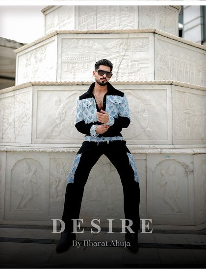 Seated with an air of authority, this image showcases the unique design of the denim patchwork co-ord set. It's a look that is both rugged and refined.