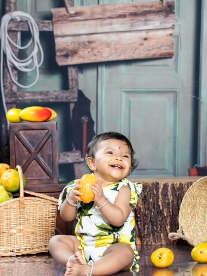 A big, happy smile from the baby enjoying her mango feast.