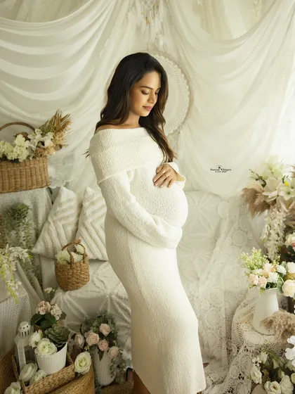 A serene and gentle solo maternity portrait in our all-white boho studio setup. The soft lighting and natural textures create a peaceful and angelic atmosphere, perfectly highlighting the pregnancy glow.