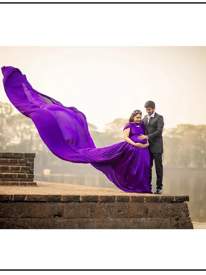 A stunning lakeside portrait with the wind catching the vibrant purple gown, creating a breathtaking effect.