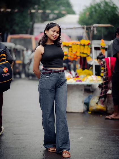 This portrait showcases a confident pose against the backdrop of a colorful flower market. It's a great example of an environmental portrait.