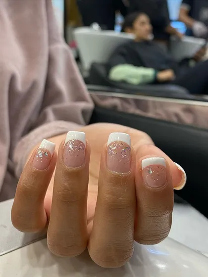 A clean and classic French manicure with a glitter fade from the cuticle, adding a touch of glamour to a timeless design.