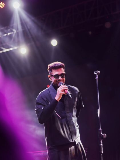 A moment of connection with the audience. The singer's smile under the spotlight shows the joy of performance and the shared energy of a live show.