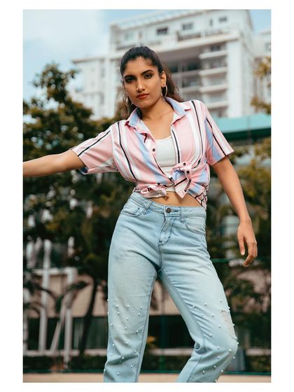 A casual outdoor portrait. The striped shirt and jeans create a relaxed, approachable look, perfect for lifestyle photography.