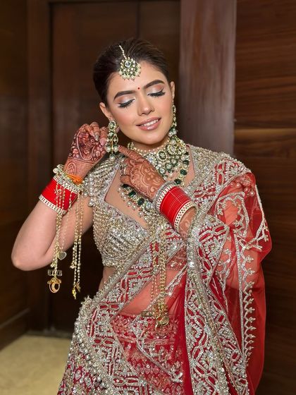 Adjusting the final details. This shot shows the beautiful side profile and the intricate work on her blouse, all tied together with a classic makeup look.