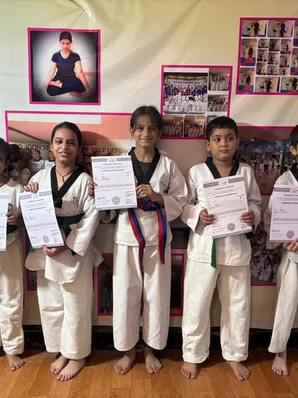 A proud moment for our taekwondo students. Dressed in their uniforms, they hold up their new belt certificates, marking a significant step up in their martial arts journey. We celebrate every milestone, big and small.