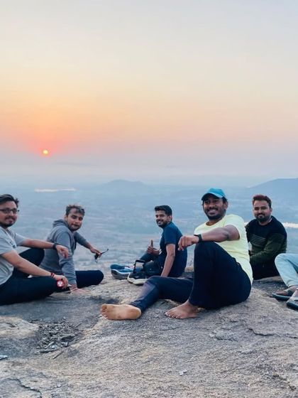 A group of friends relaxing on the rocks at the summit, enjoying the first rays of the sun.