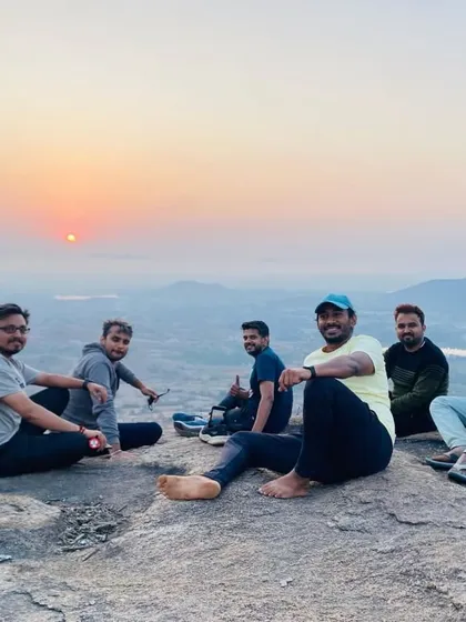 A group of friends relaxing on the rocks at the summit, enjoying the first rays of the sun.