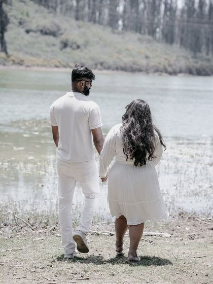 A couple walks hand-in-hand towards a lake in Ooty, a serene and peaceful shot capturing the beauty of the location.