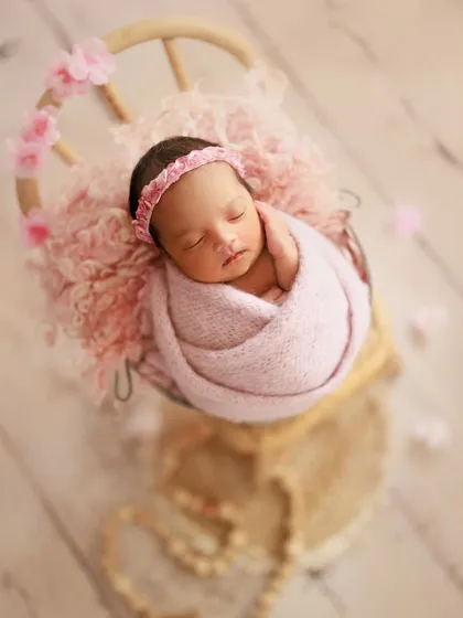Pretty with pink and sakura blossoms. This setup uses a soft pink wrap and headband, with delicate petals scattered around for a lovely springtime feel.