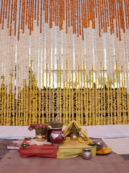 For a traditional Haldi ceremony, we created a stunning backdrop using strings of fresh marigolds in shades of orange, white, and yellow. The setup for the puja was kept simple and sacred, focusing on the beauty of the ritual.