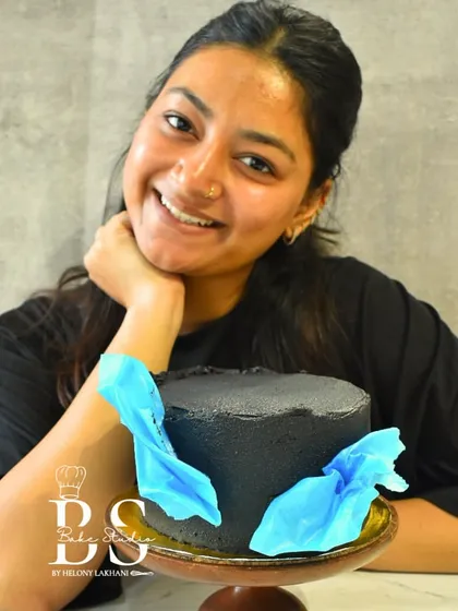 A proud student from my masterclass showcasing her ganache cake, beautifully decorated with delicate blue wafer paper fans. It's amazing to see my students' skills grow.