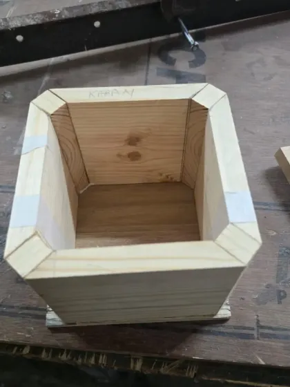 An inside look at the box during construction. The mitered corners are reinforced with small corner blocks for added strength, and the edges are temporarily held with tape while the glue dries.
