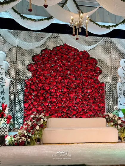 A full view of the red rose arch, a powerful and romantic statement piece that serves as the main backdrop for the couple.