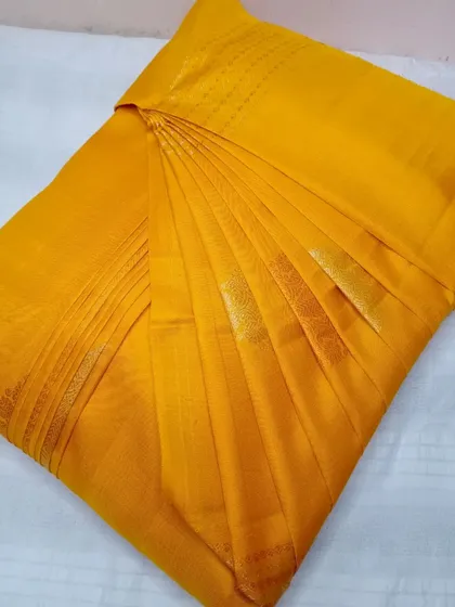 A bright mustard yellow saree, pleated for a perfect, time-saving drape.