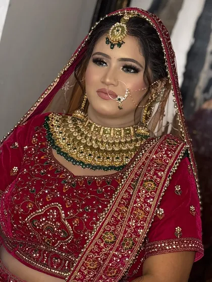 A three-quarter profile of the bride, showing off her contoured cheekbones and the beautiful details of her nath and maang tikka.