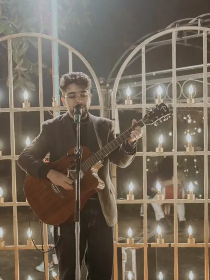 Performing solo against a beautifully lit backdrop. This kind of setup is great for creating an intimate and romantic atmosphere during a wedding dinner or cocktail hour.