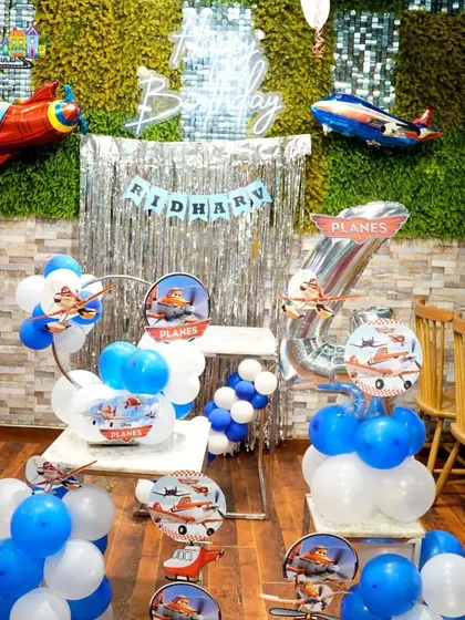 Taking flight with a 'Planes' themed party. The decor, including airplane balloons and a silver curtain backdrop, created an adventurous atmosphere.