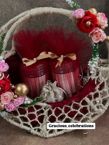 A beautiful and rustic wedding favor option. This jute and net basket is decorated with red and pink flowers and can be filled with jars of sweets or other small gifts.
