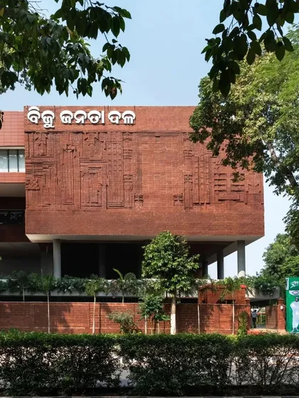 The building's main facade features a large, carved laterite panel depicting motifs from Odisha's agricultural and weaving heritage.