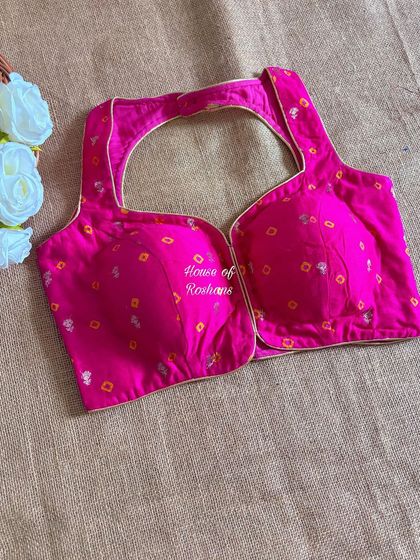 A closer look at this beautiful pink bandhej blouse. The fabric is soft and the cut is modern, making it a comfortable yet stylish festive choice.