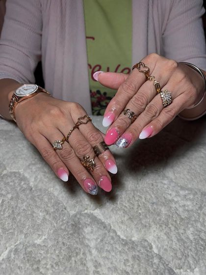 A lovely pink and white ombre set with a silver glitter accent nail, perfect for a soft, glamorous look.