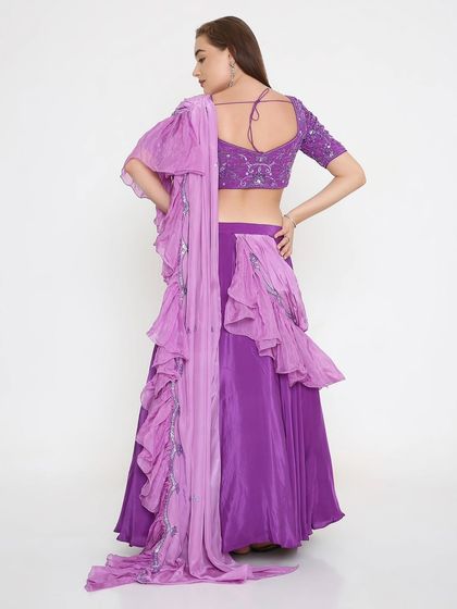 A statement from the back. This lavender lehenga features an intricately embroidered tie-back blouse and a dramatic layered ruffle dupatta, ensuring you look stunning from every angle.
