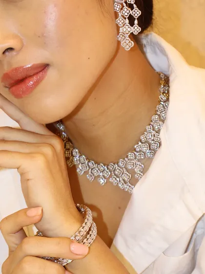 Iced out in TMJ. This floral-patterned diamond necklace is paired with matching chandelier earrings for a look that is pure glamour.