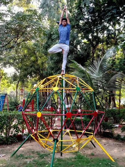 Yoga is about elevating our competence in all aspects of life. Here, I practice Tree Pose in an unconventional setting to demonstrate that balance and focus are skills we can apply anywhere, rising above the complexities of our environment.