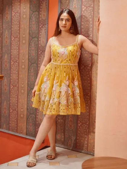 Let the details do the talking. This yellow Indo-Western short dress with floral and pearl embroidery is full of charm.