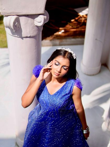 This pose highlights the harmony between the makeup and the elegant silhouette of the gown. The defined eyes and soft lip color ensure the model's face is a beautiful focal point without overpowering the fashion.