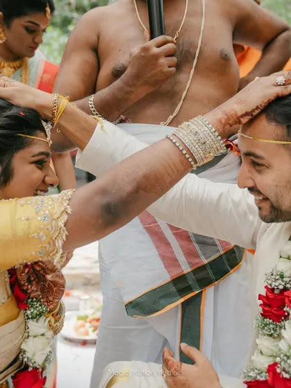 A close-up of the 'jeerige bella' ritual, a moment of sweet connection between the bride and groom.