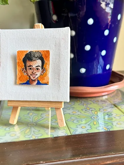My mini portrait of Pratham on an easel.