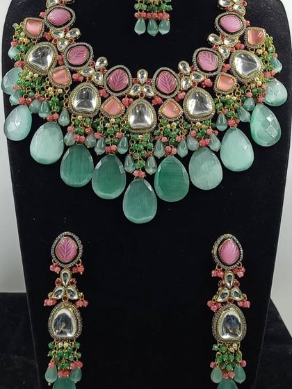 A designer-inspired necklace set with large mint green drops and pink stone accents.