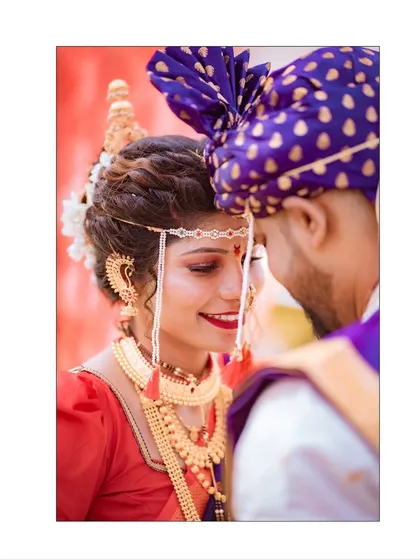 An intimate close-up of a Maharashtrian bride and groom. The bride's beautiful smile and the traditional mundavalya create a classic and emotional wedding portrait.
