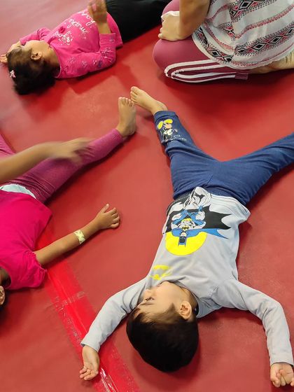Even rest time is part of the process. Children lie on our bright red mats, taking a moment to relax and recharge between activities.