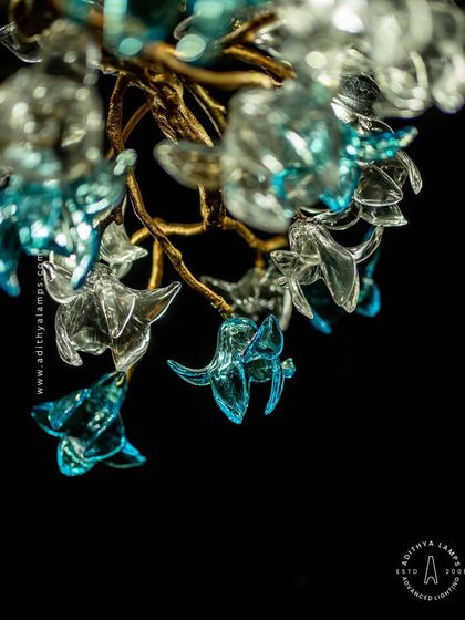 This enchanting chandelier is a bouquet of light, composed of dozens of hand-blown glass flowers in clear and soft blue hues. The intricate design creates a magical, garden-like atmosphere, perfect for a romantic bedroom or elegant dining space.