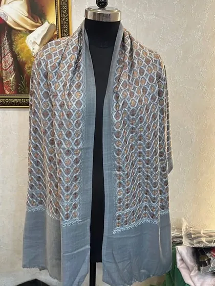 This grey pashmina has a unique embroidered pattern with hints of gold. It's a beautiful and subtle way to add some sparkle to your look.