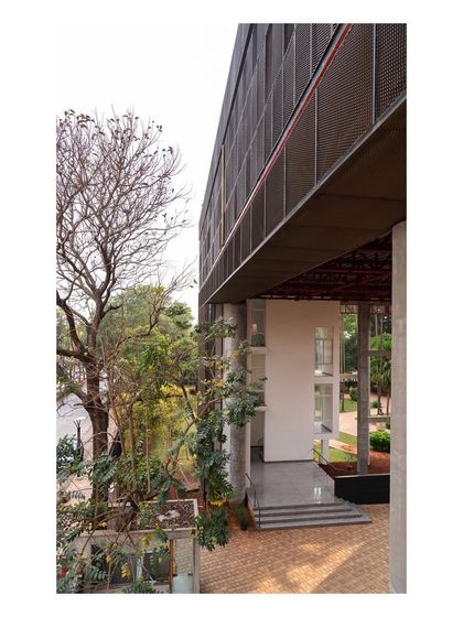 The "Hoverspace" extension forms a portal-like entrance to the campus. The new structure respectfully frames the old, creating a layered and cohesive architectural composition.