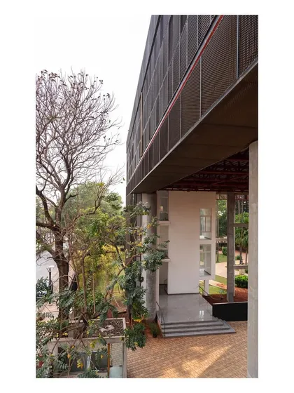 The "Hoverspace" extension forms a portal-like entrance to the campus. The new structure respectfully frames the old, creating a layered and cohesive architectural composition.