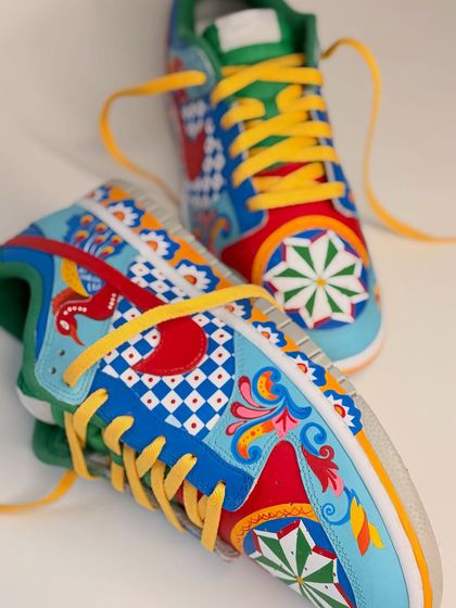 A close-up of the intricate patterns on the custom Nike Dunks. The design includes floral elements, checkerboard patterns, and geometric stars, all hand-painted with bright, eye-catching colours.