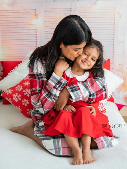A mother and daughter's sweet embrace. The matching pajamas and festive setting make this a perfect portrait for a holiday card.