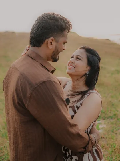 A beautiful, candid shot of the couple looking at each other with smiles. The natural, golden light of late afternoon adds a warm glow to this romantic moment.