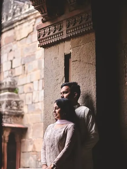 A beautifully composed shot using natural light and shadows within a stone corridor. This kind of artistic pre-wedding portrait highlights the couple's connection in a subtle, elegant way.