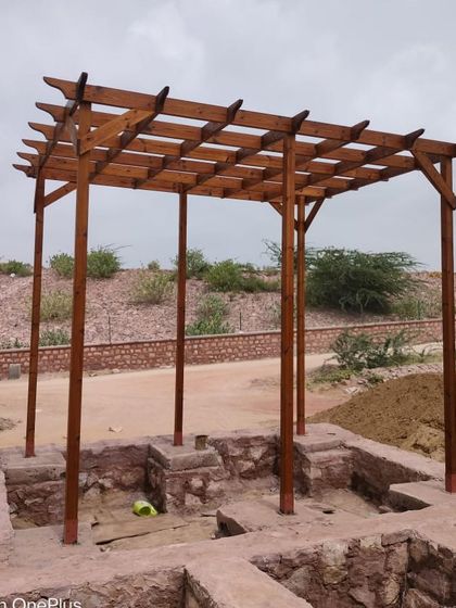 A freestanding Thermopine wood pergola constructed for a public space at Surpura Dam, Jodhpur. This structure is designed to provide shade and a focal point in the landscape.