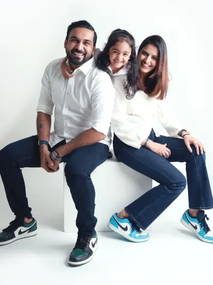 A cool and casual family portrait. Matching sneakers and relaxed smiles show off this family's fun personality during their studio session.